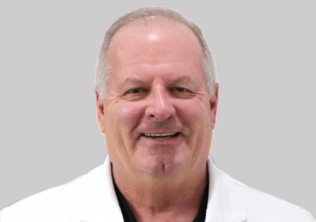 Portrait of Smiling Man Wearing a Pink Suit and Blue Shirt Dr. Todd Whitefield working at Abilene Dental Care